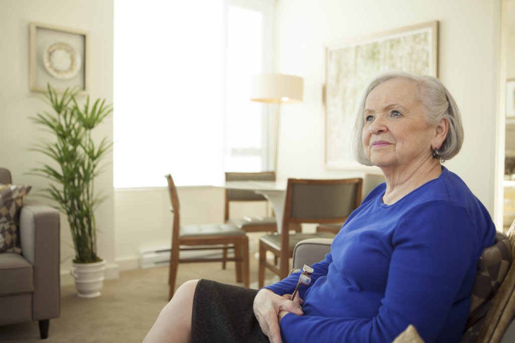 Senior woman sitting in her suite