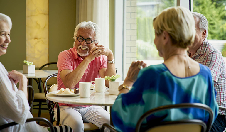 Residents socializing around a bistro table