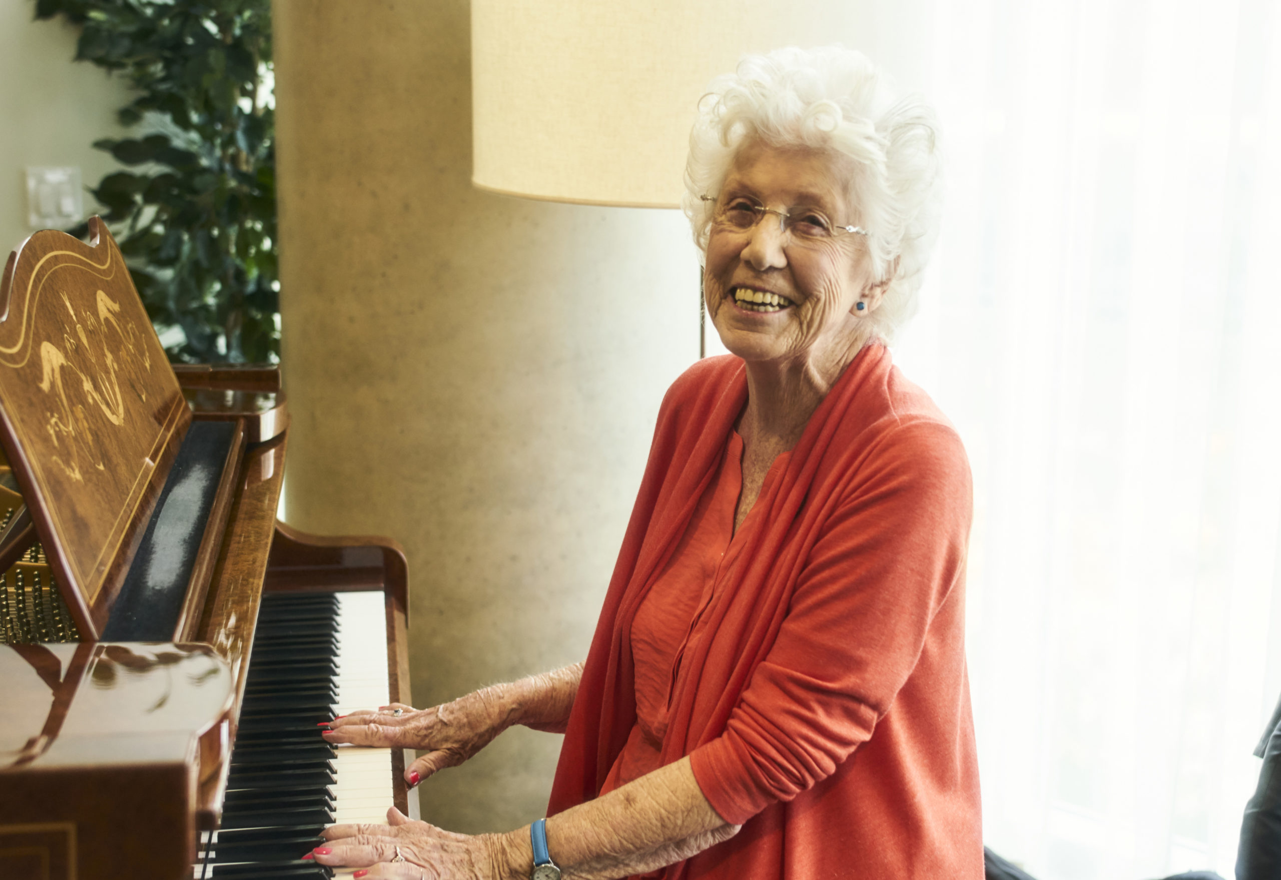 Westerleigh PARC resident Dorothy smiling and playing the piano