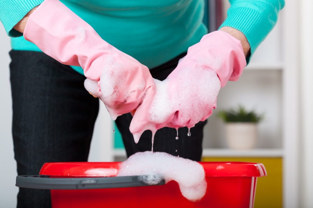 Senior woman cleaning in rubber gloves